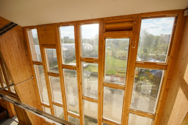 Façade-rideau : montants en bois et ventaux de fenêtres réemployés [Raphael Pauschitz / Topophile]