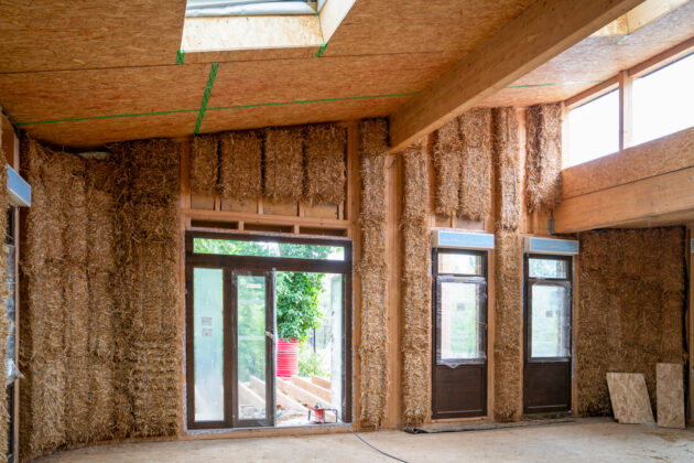 Les bottes de paille sont insérées dans l'ossature par l'intérieur sur site // Archipel zéro - Lao / Topophile