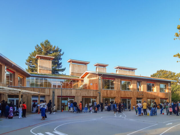 L'école surmontée de ses cheminées de ventilation naturelle depuis la cour // DRI - ville de Rosny-sous-Bois / Topophile